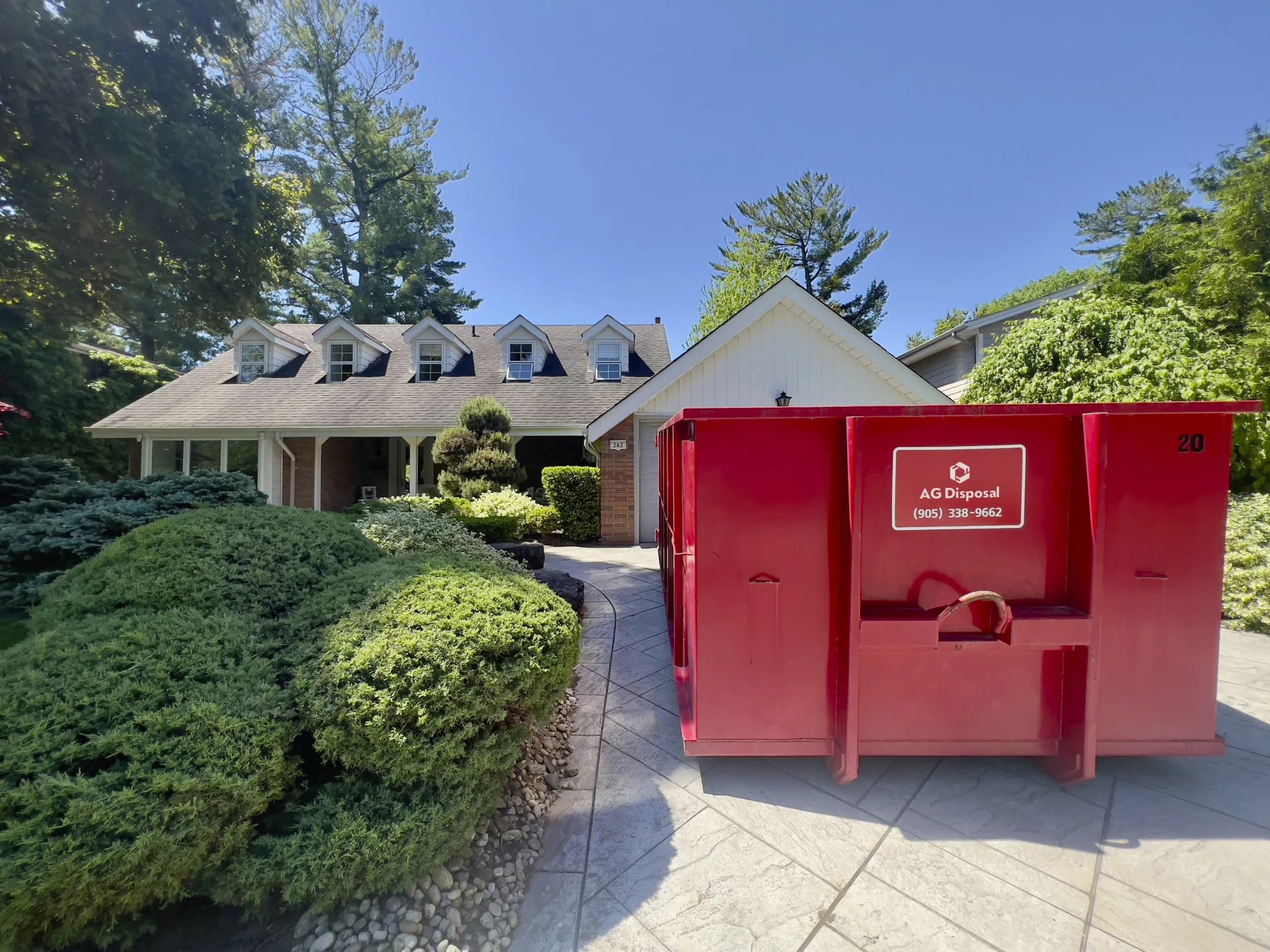 Red AG Disposal bin on a suburban driveway