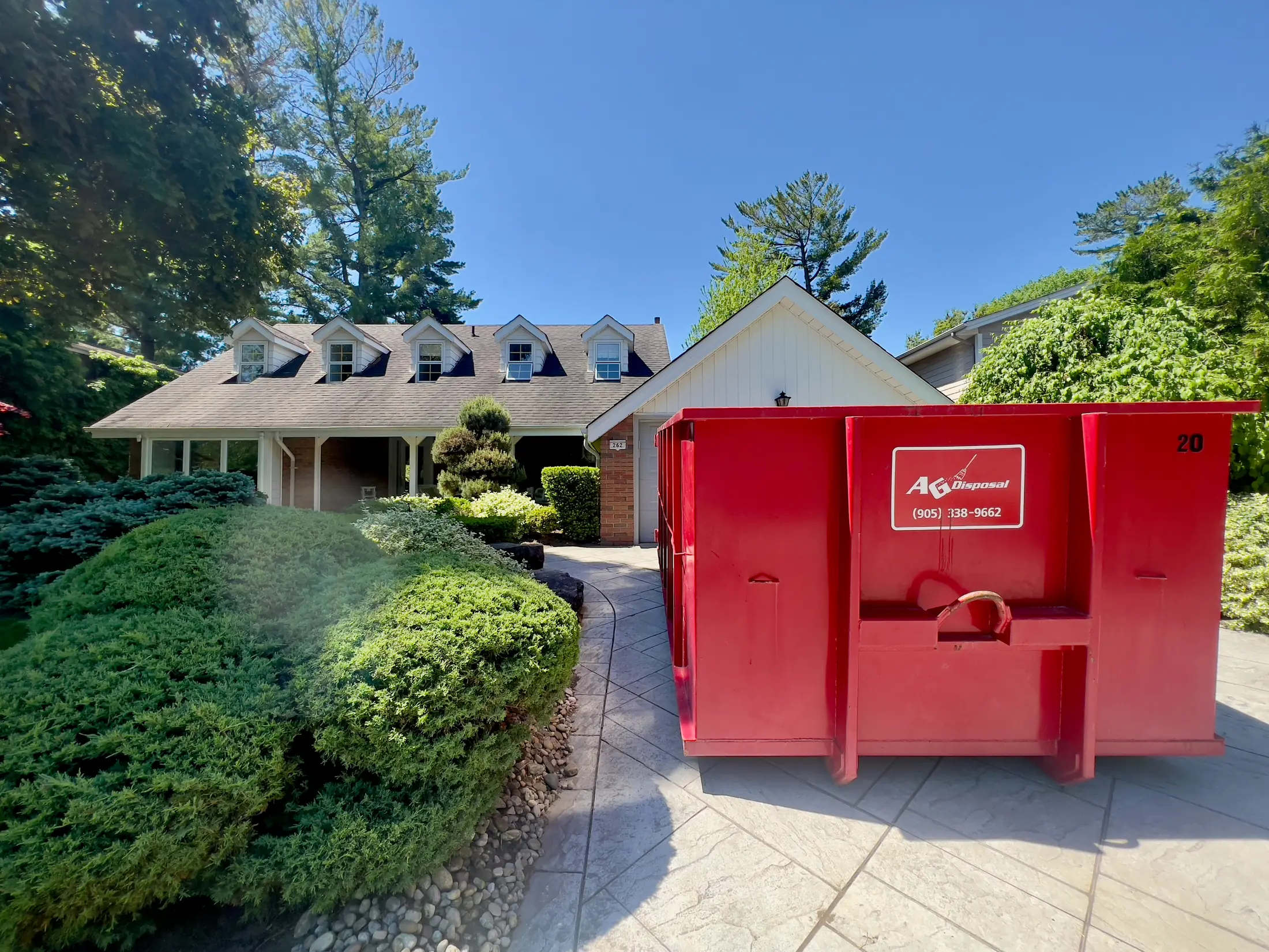 Red AG Disposal bin on a suburban driveway